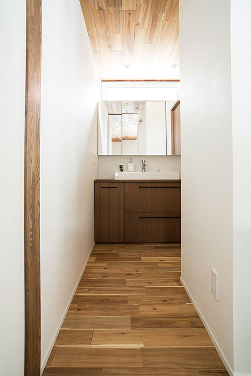 落ち着きのある造作家具でまとめられたユーティリティ。上部に採光窓が設けられ、ほどよく明るい空間に