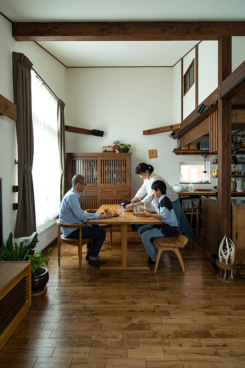 ダイニングの様子。奥にあるチェストはご夫妻がもともと所有されていたもので、この色に合わせて全体のカラーリングが設定された。南向きの窓は、太陽光をより多く採り入れられるように背が高くなっている